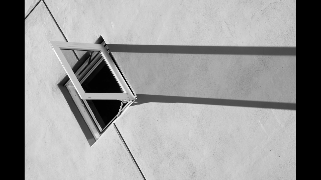 An open window on a concrete wall with shadow